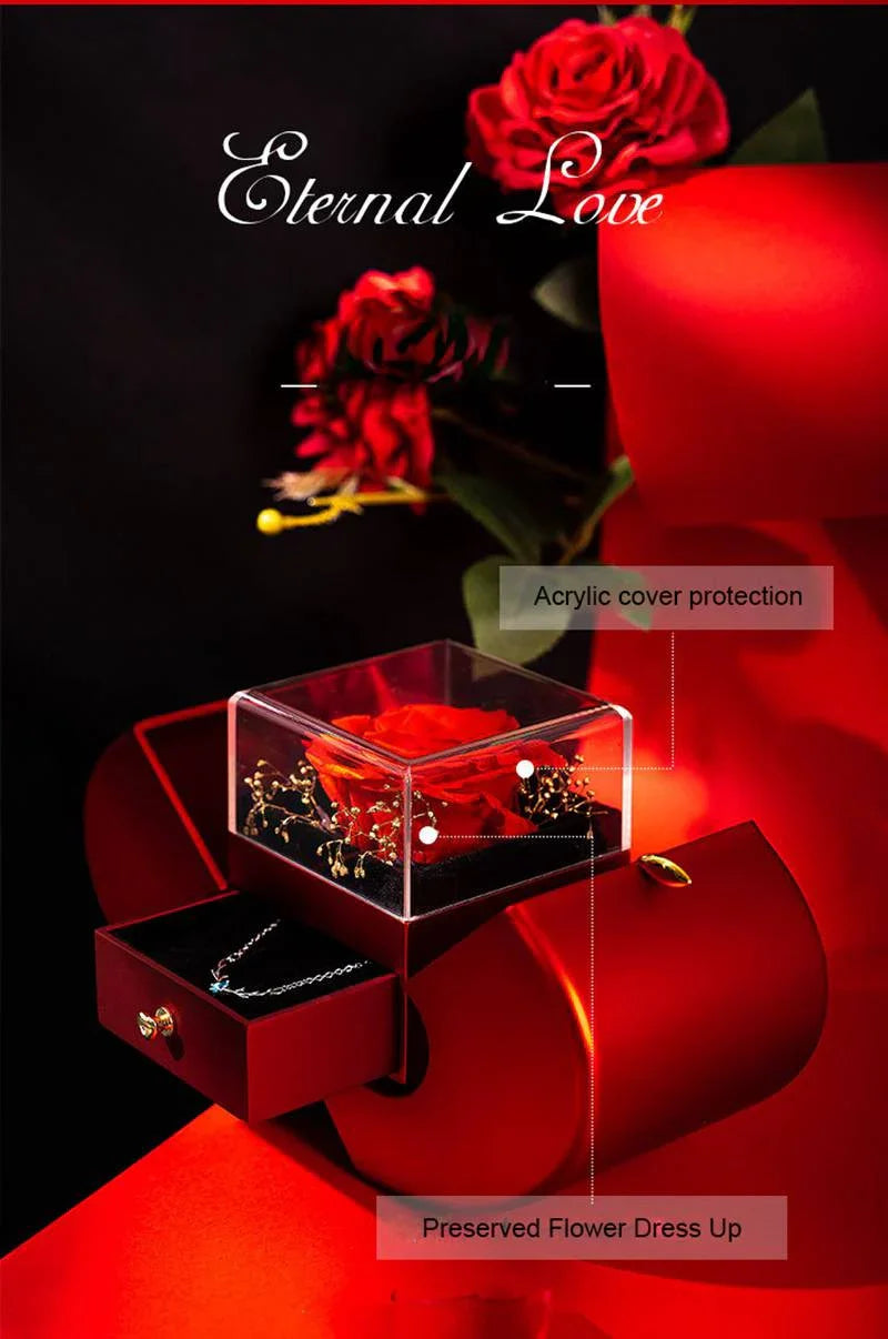 Red preserved rose in acrylic box with jewelry drawer on red velvet chair under Eternal Love text