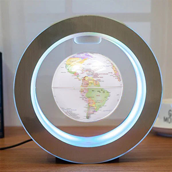 Modern levitating globe lamp with blue LED light and metal ring frame on wooden desk