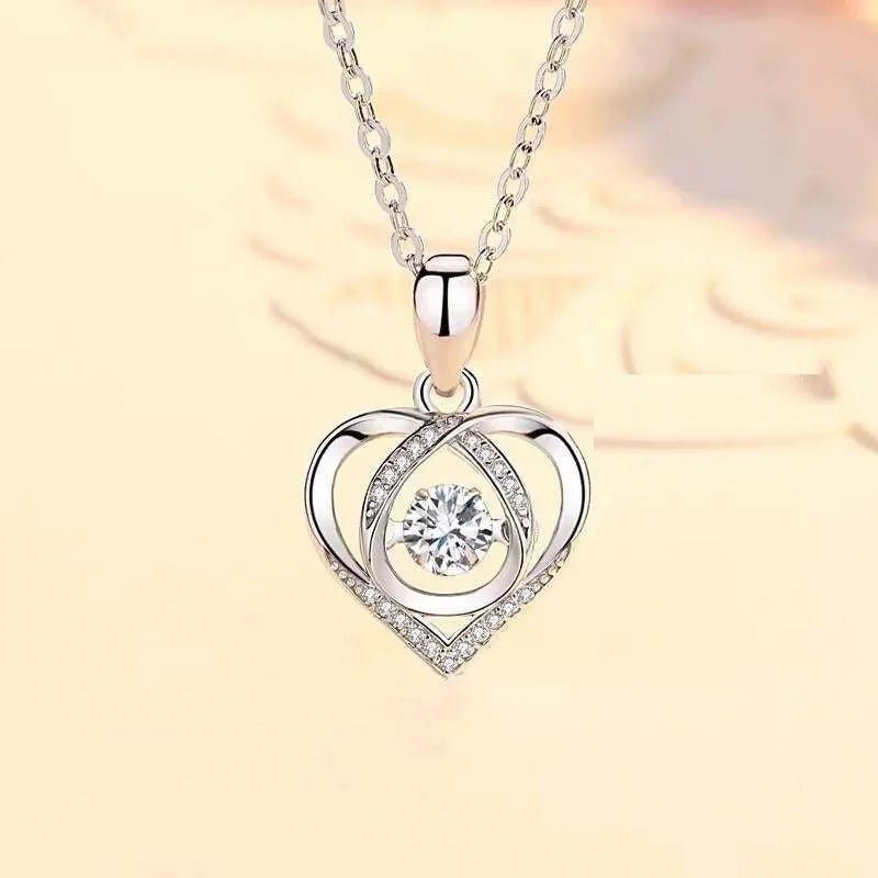 silver heart-shaped pendant necklace with central sparkling diamond and small crystals on a chain