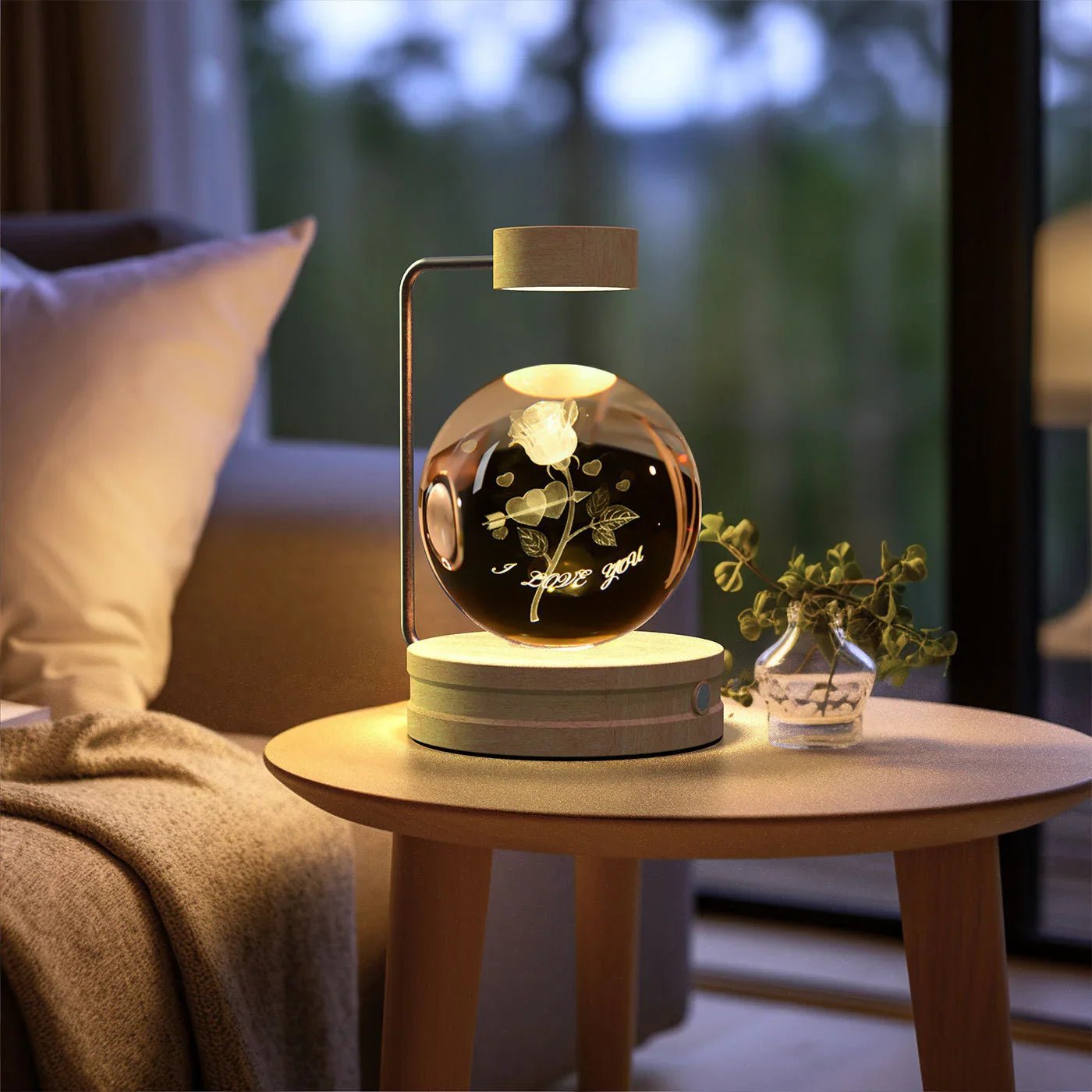 Levitating glass orb with engraved rose and I love you text on wooden table lamp in cozy living room