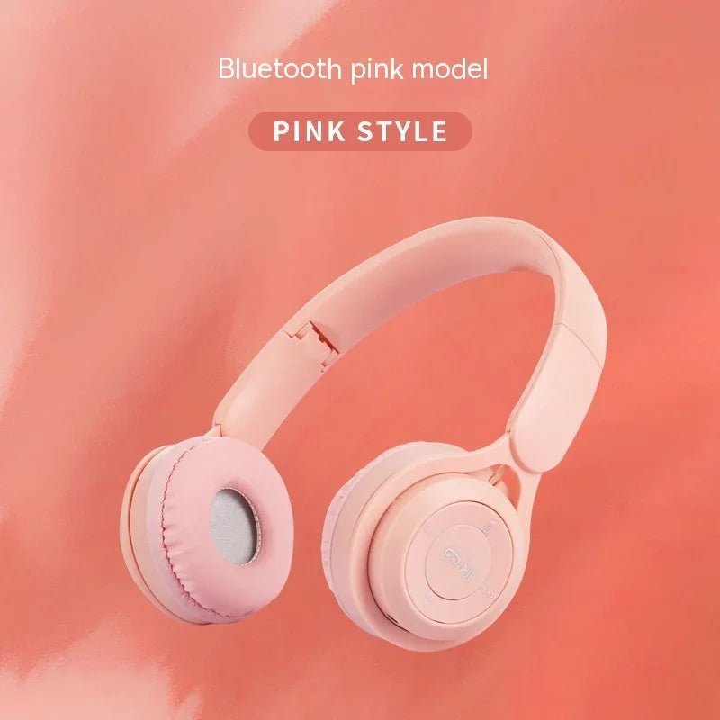 Pink wireless Bluetooth headphones with cushioned ear pads on pink background